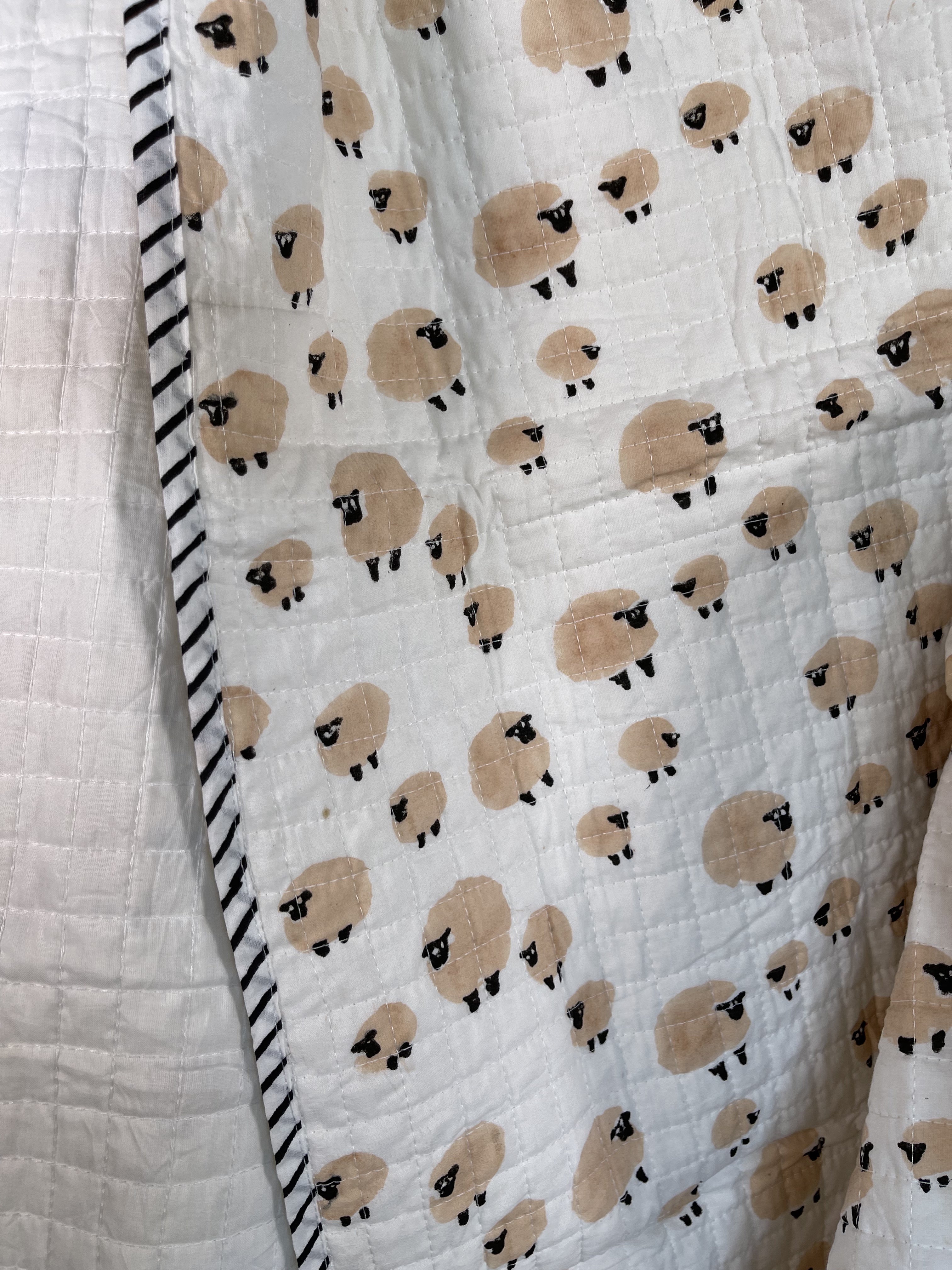 Handblock printed cotton baby quilt, machine stitched in small squares for easy care and washing. Lightly padded with cotton.