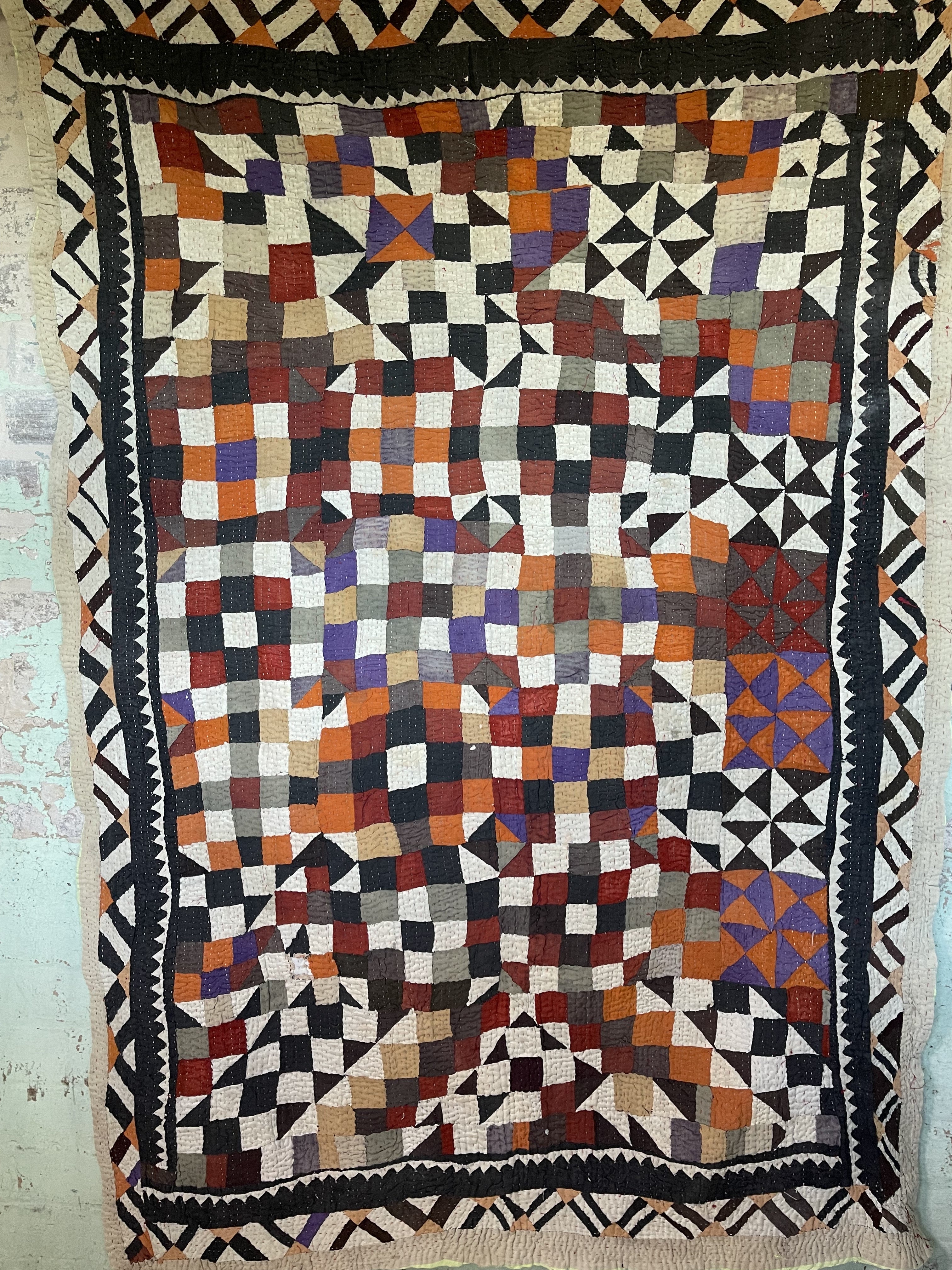 This particular quilt has an unusual combination of triangles and sqaures creating an enchanting and visually disruptive pattern. The reverse a vintage handblock printed piece of fabric that looks like coffee pots printed on the diagonal.