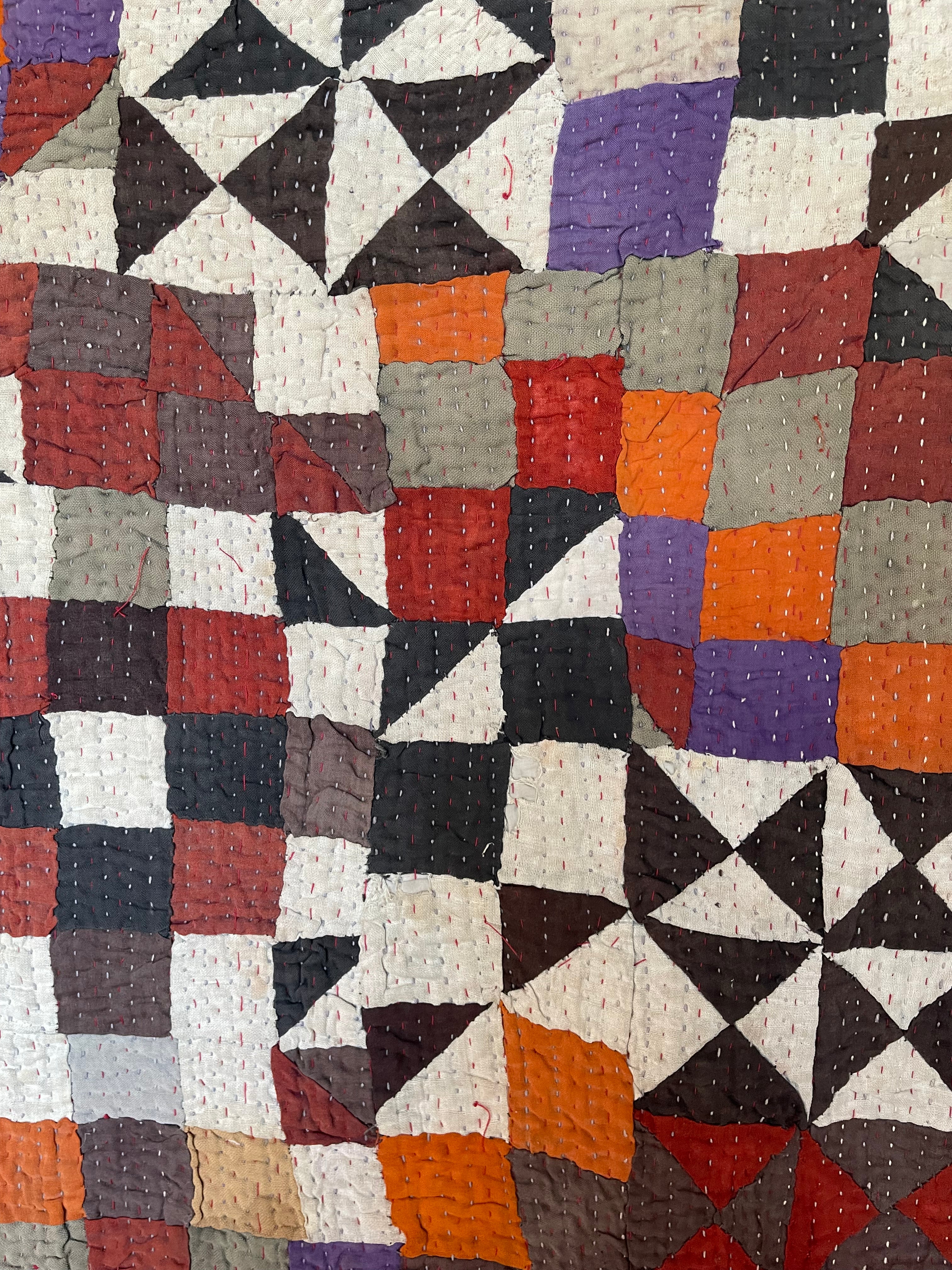 This particular quilt has an unusual combination of triangles and sqaures creating an enchanting and visually disruptive pattern. The reverse a vintage handblock printed piece of fabric that looks like coffee pots printed on the diagonal.