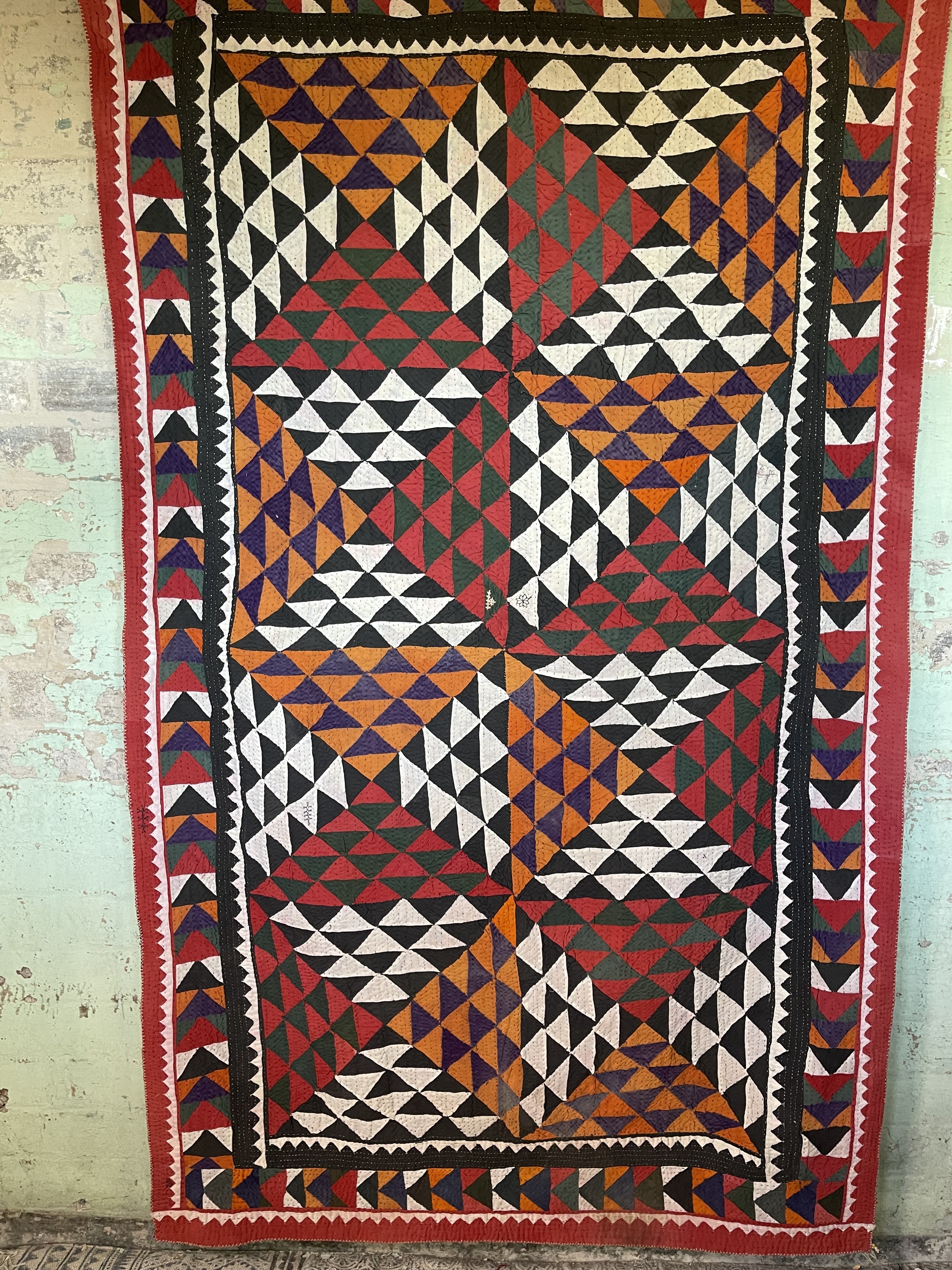 This ralli illustrates one of the most typical everyday quilts. The color scheme is based on the old, natural dyes colors even though chemical dyes are now used. The size of the fabric used in the piecing is typical for an everyday quilt. The geometric design is bold, especially when viewed from a distance.