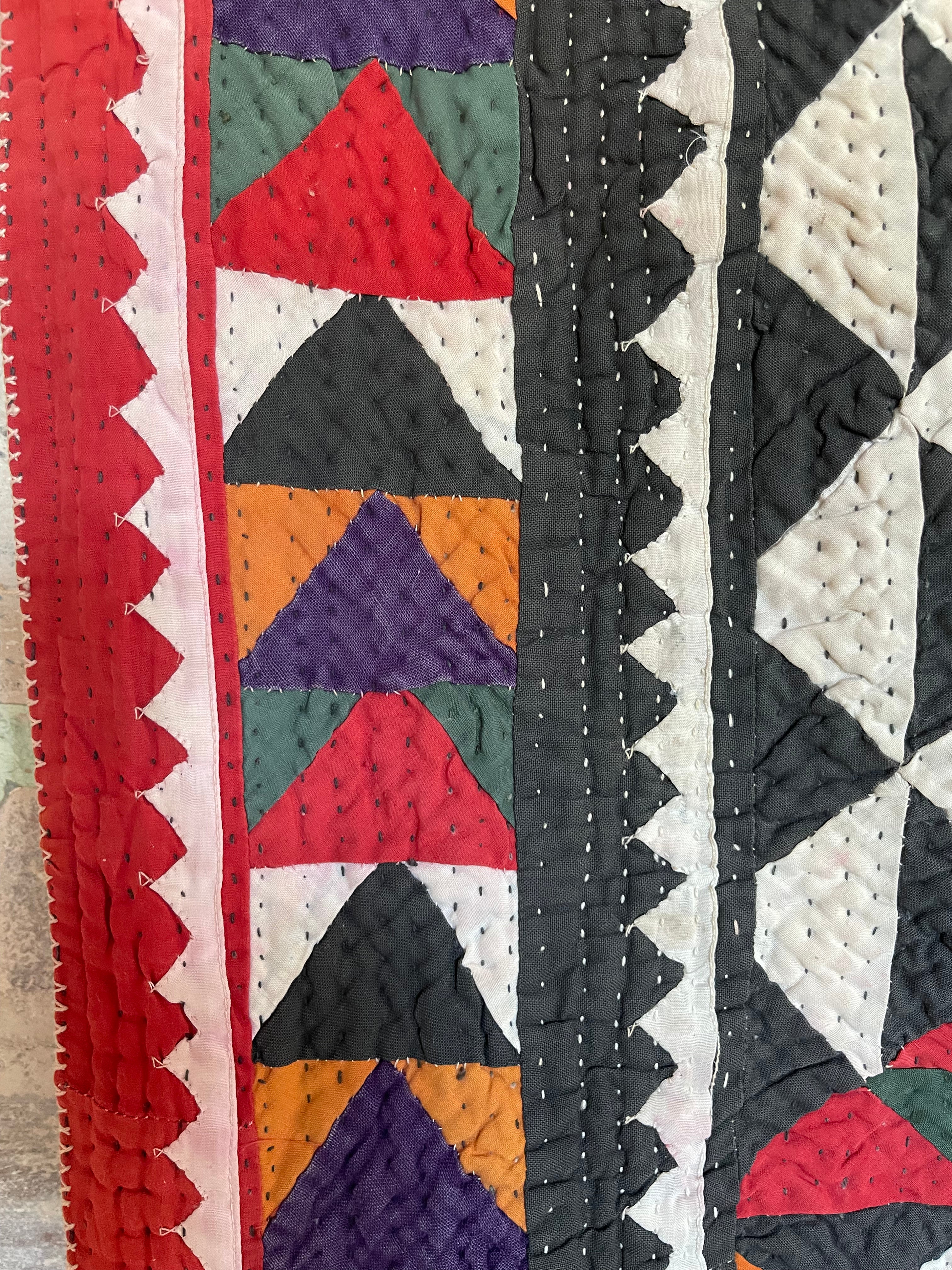 This ralli illustrates one of the most typical everyday quilts. The color scheme is based on the old, natural dyes colors even though chemical dyes are now used. The size of the fabric used in the piecing is typical for an everyday quilt. The geometric design is bold, especially when viewed from a distance.