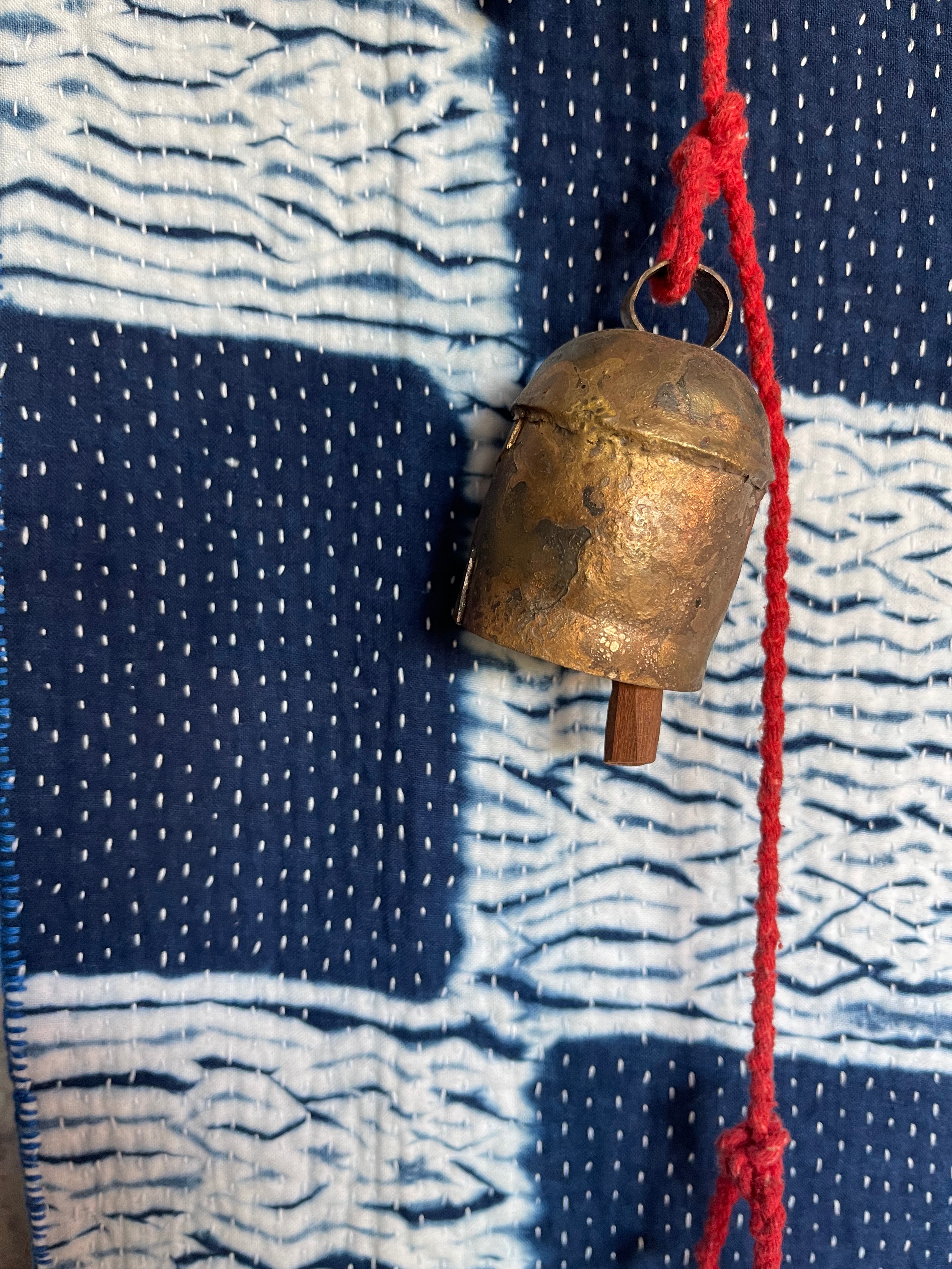A sunningly beautiful indigo shibori kantha quilt, made by the artisans of LIVING BLUE. The front a check pattern, the reverse showing fine white hand stitiching on a plain indigo background.