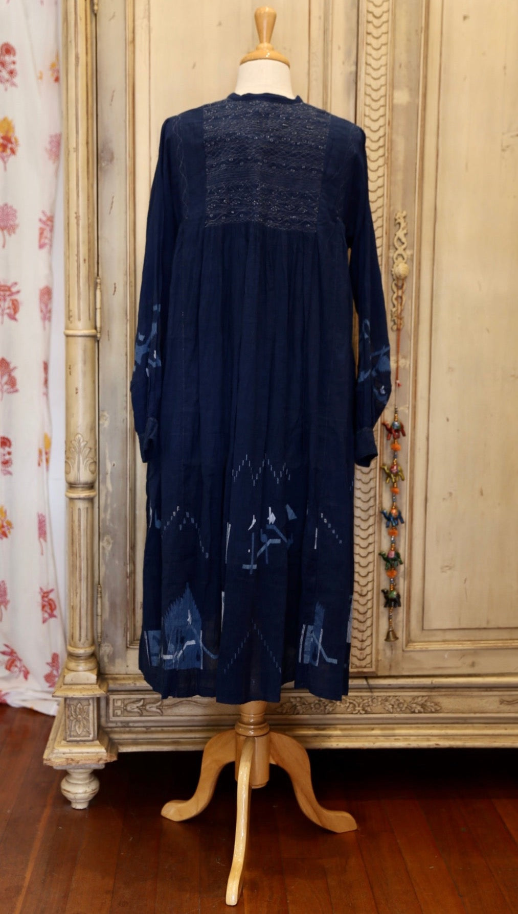 Neel 10 Easy to wear mid length ink blue indigo day dress with round neck and contrasting french blue stitching detail across bodice. The bodice opens down the front and features five tiny hand wrought buttons sewn in contrasting thread. 