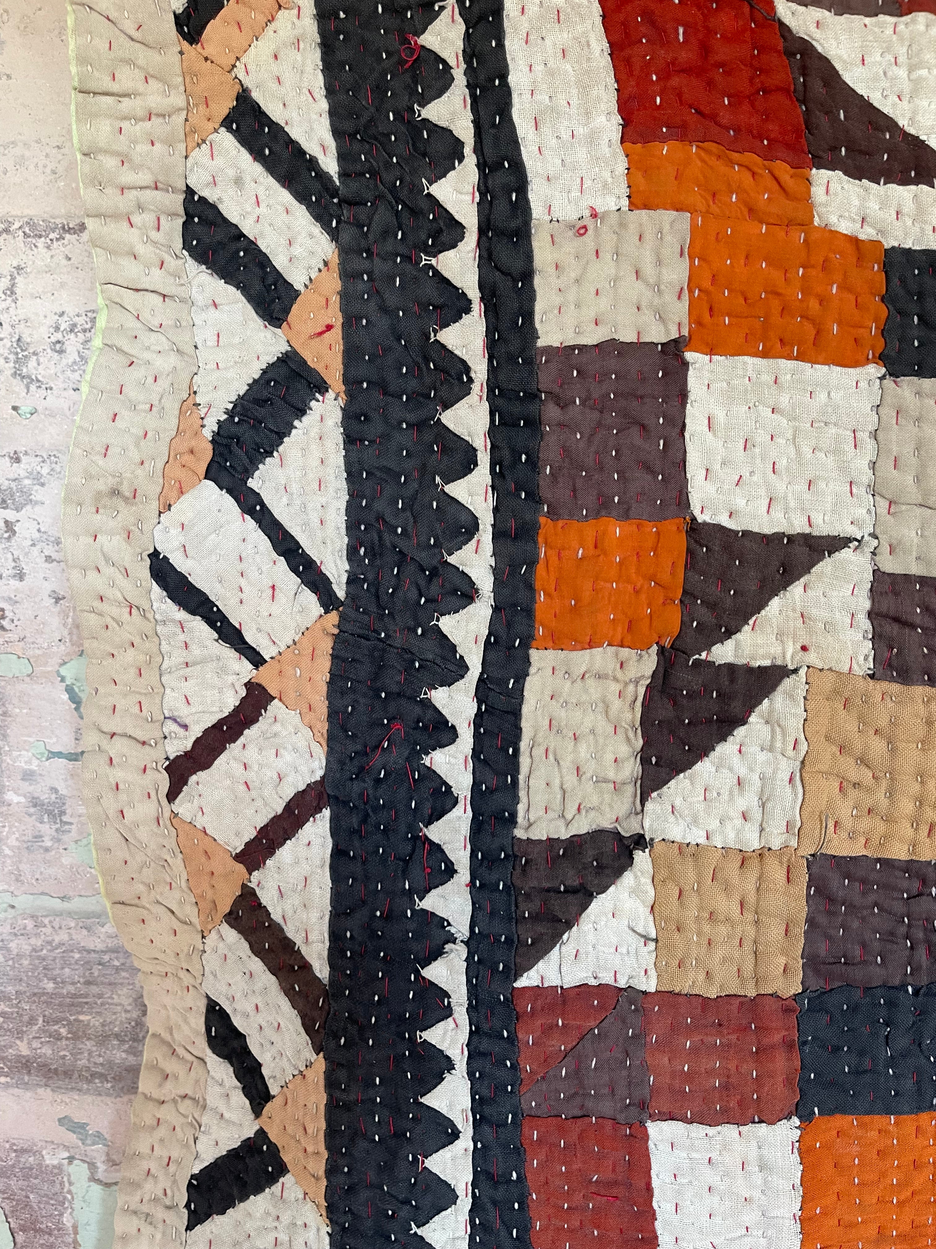 This particular quilt has an unusual combination of triangles and sqaures creating an enchanting and visually disruptive pattern. The reverse a vintage handblock printed piece of fabric that looks like coffee pots printed on the diagonal.