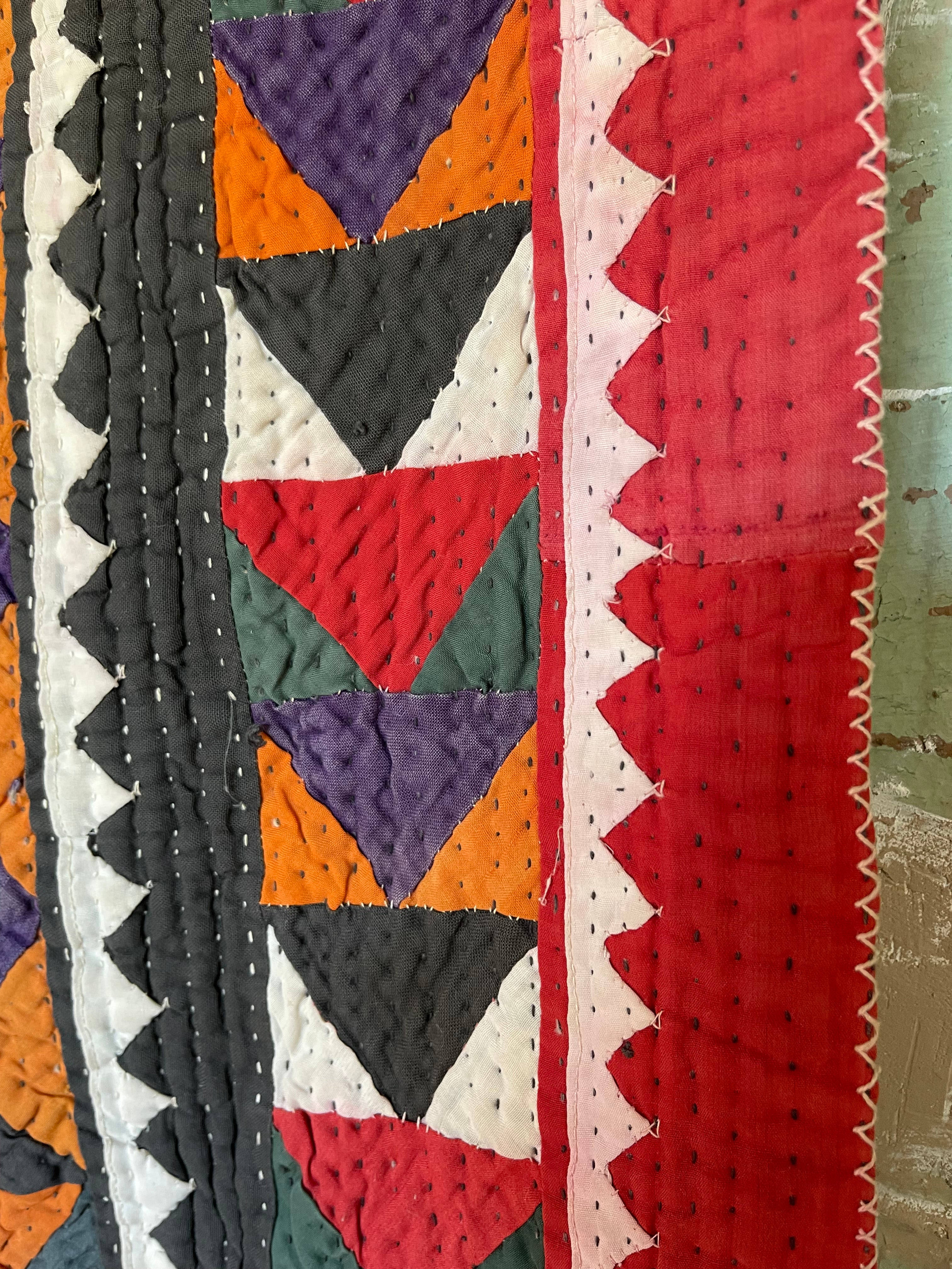 This ralli illustrates one of the most typical everyday quilts. The color scheme is based on the old, natural dyes colors even though chemical dyes are now used. The size of the fabric used in the piecing is typical for an everyday quilt. The geometric design is bold, especially when viewed from a distance.