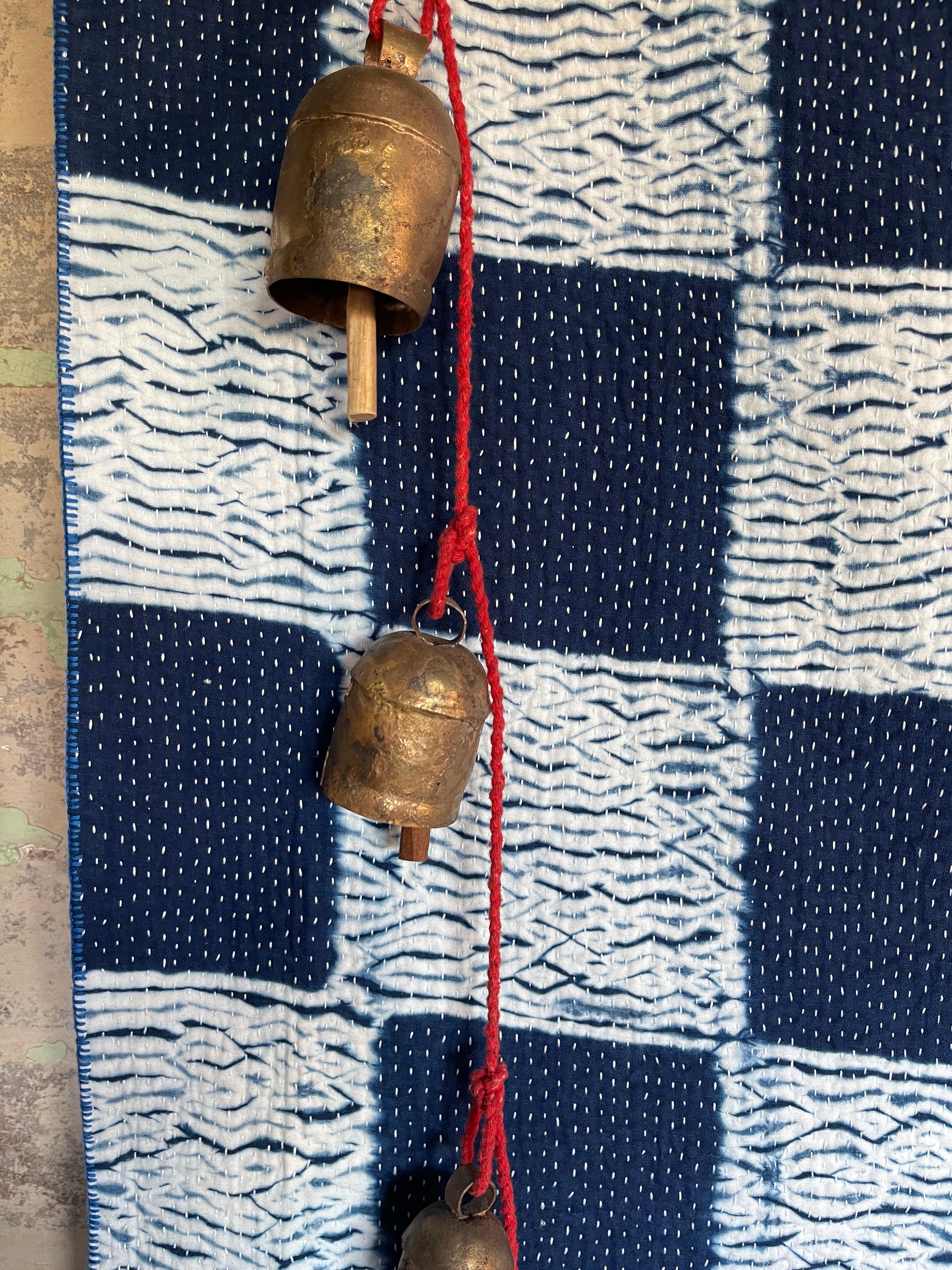 A sunningly beautiful indigo shibori kantha quilt,  made by the artisans of LIVING BLUE. The front a check pattern, the reverse showing fine white hand stitiching on a plain indigo background.